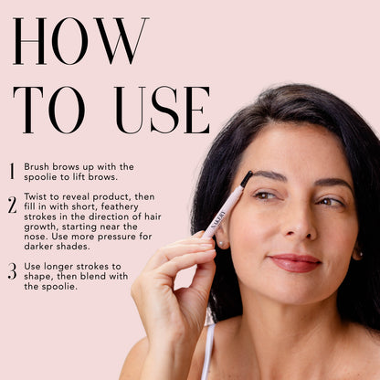 Model demonstrating how to apply Nakery Beauty Instant Brow Filler using the spoolie brush and short, feather-like strokes for fuller, defined brows.