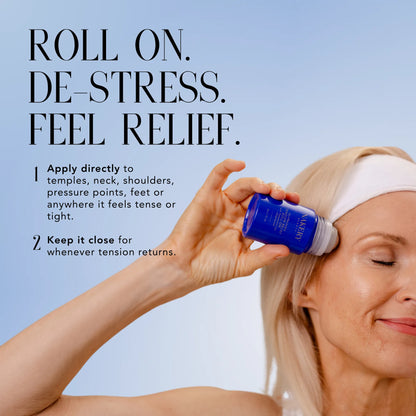 Woman applying Nakery Beauty Tension Relief Roll-On to her temple for targeted relief from tension and tightness.